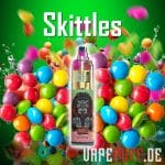 A vibrant mix of Skittles candy with Randm Tornado 7000 vape, showcasing colorful spheres and a green backdrop.